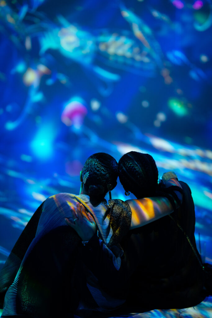 lesbian couple on a date with their arms around each other in the immersive backdrop